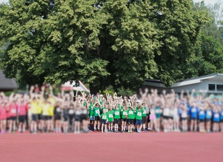 alle Teams in der Kurve der Tartanbahn vor einem Baum
